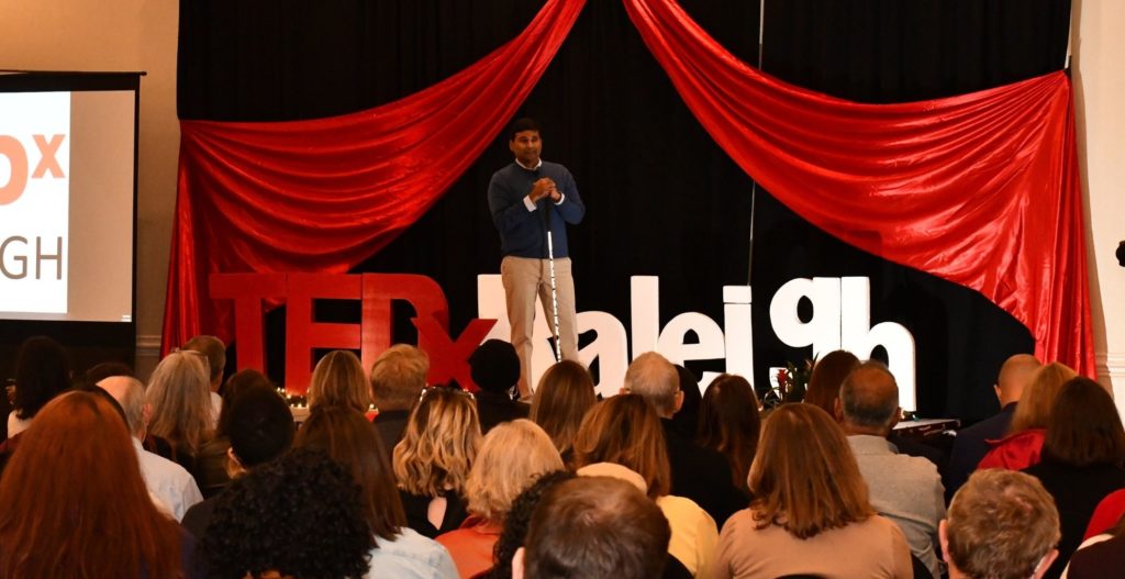 View of the crowd and John on stage as TedX Raleigh